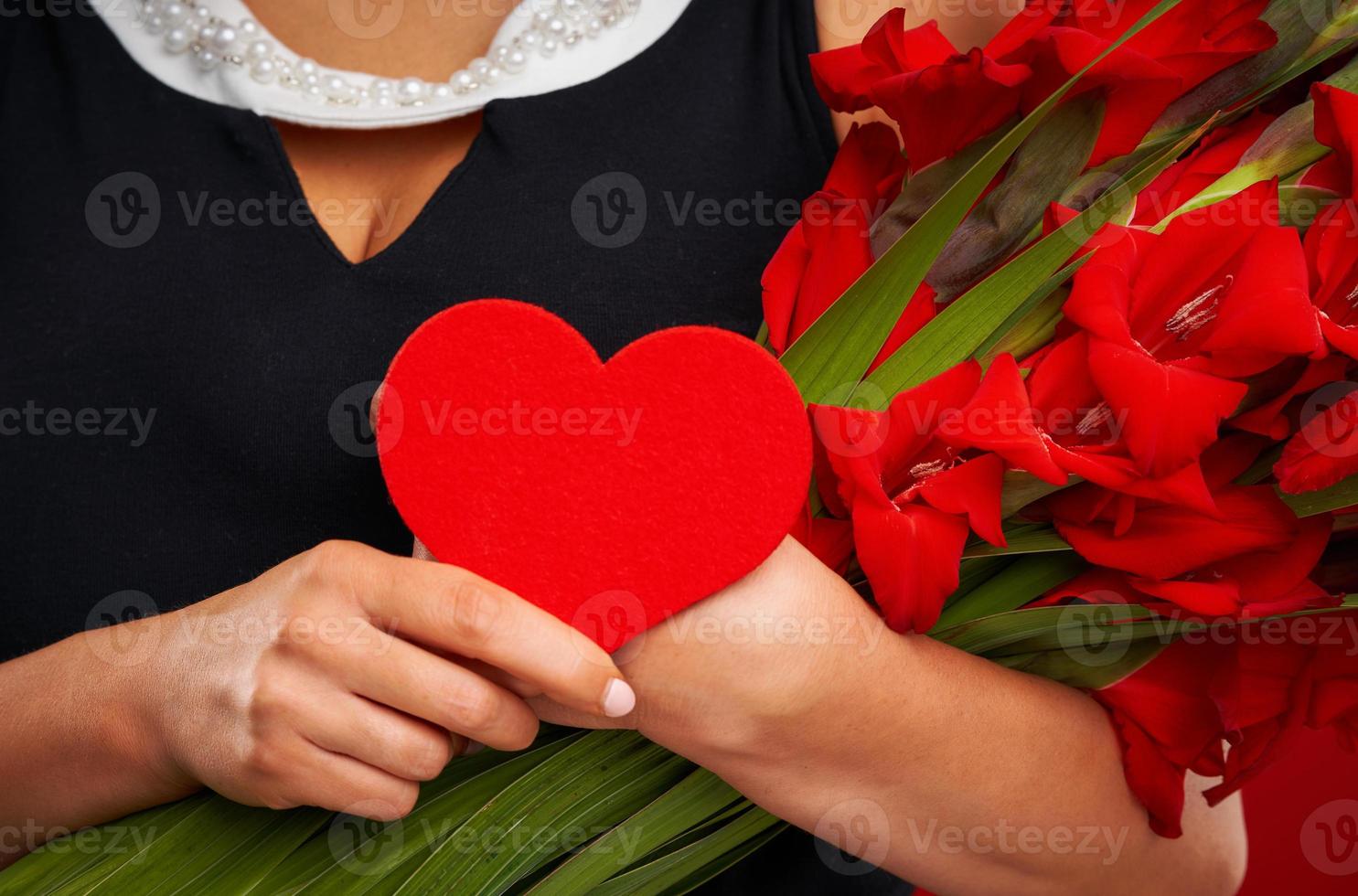 Adult woman with flowers and red heart over red background photo