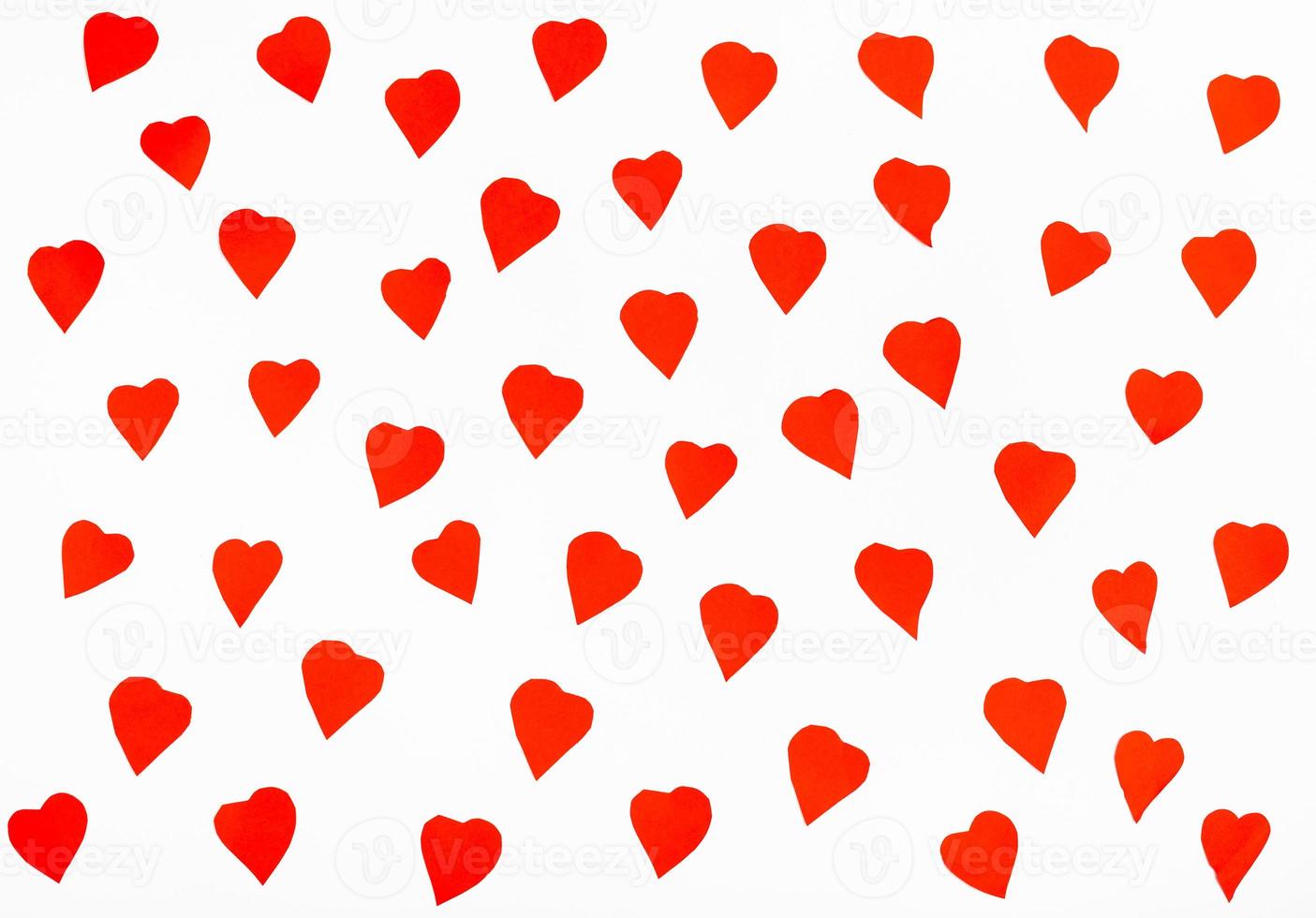 many red hearts cut out from paper on white photo
