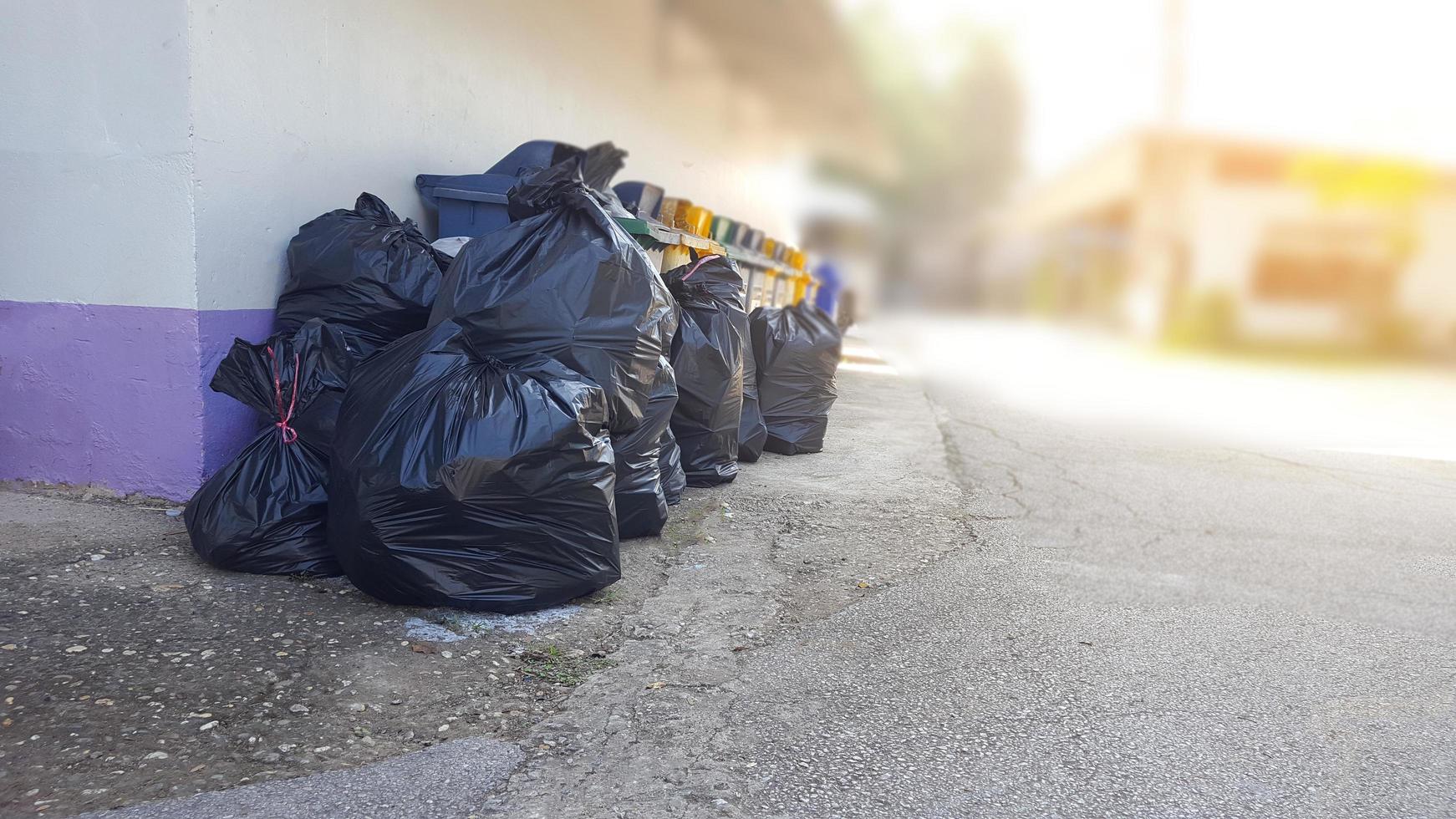 bolsas de basura de plástico negro en el suelo esperando el reciclaje foto