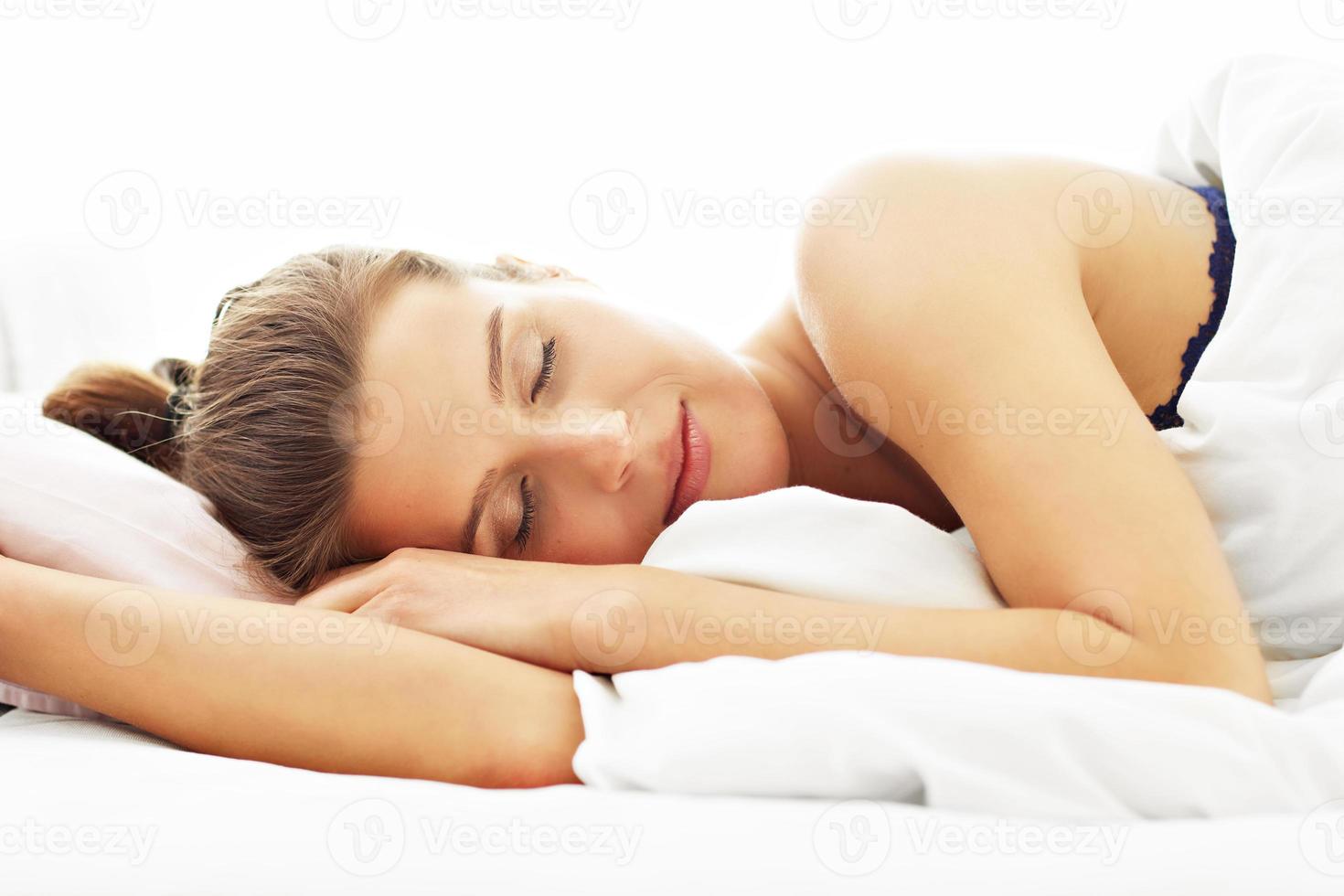 mujer joven durmiendo en la cama foto