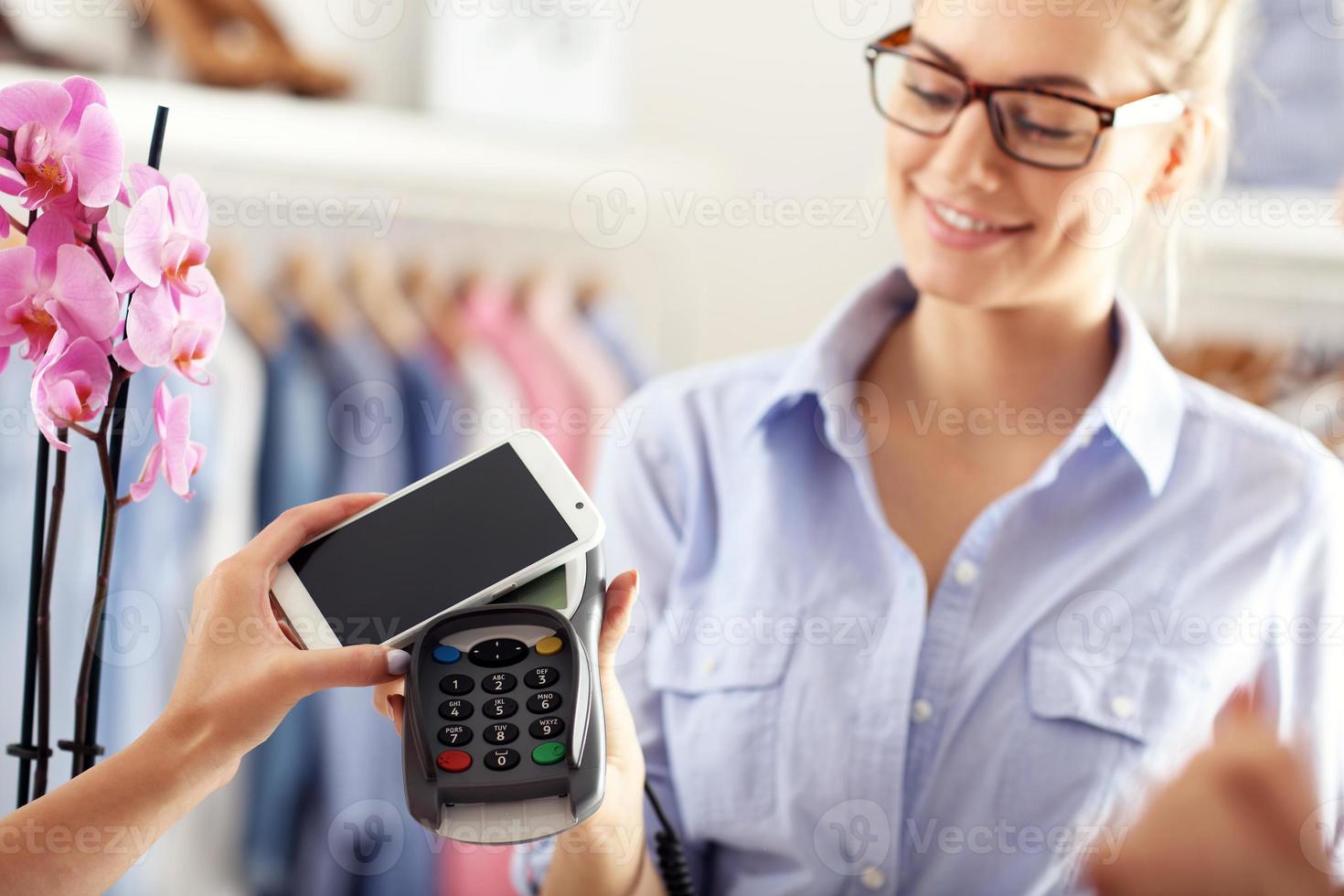 Closeup mid section of female customer paying in shop with credit card photo
