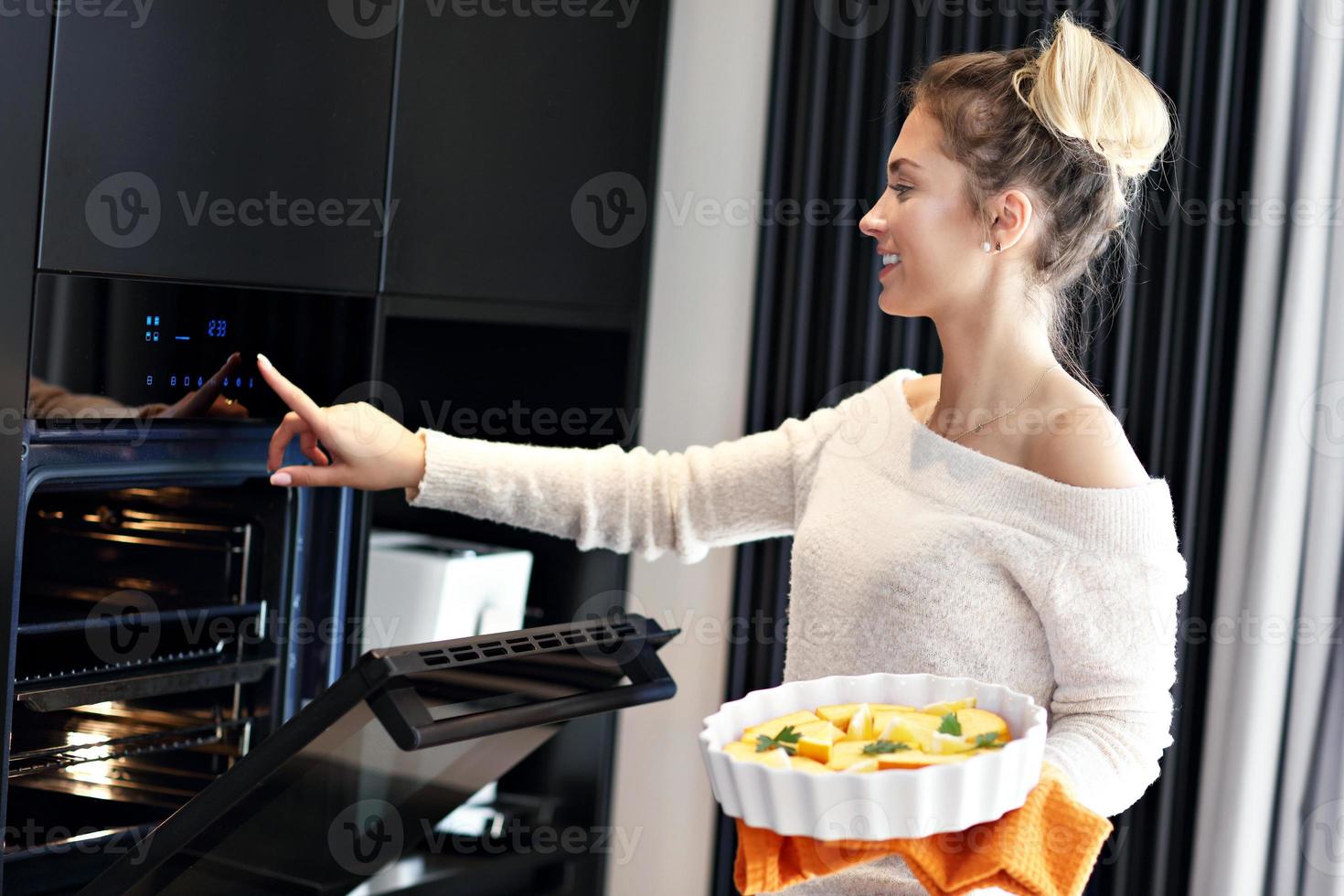 mujer adulta en la cocina preparando platos de calabaza para halloween foto