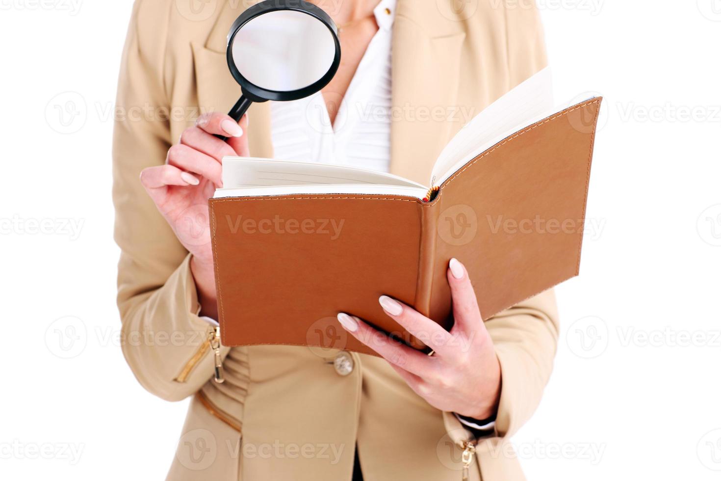 Businesswoman with agenda and magnifying glass photo