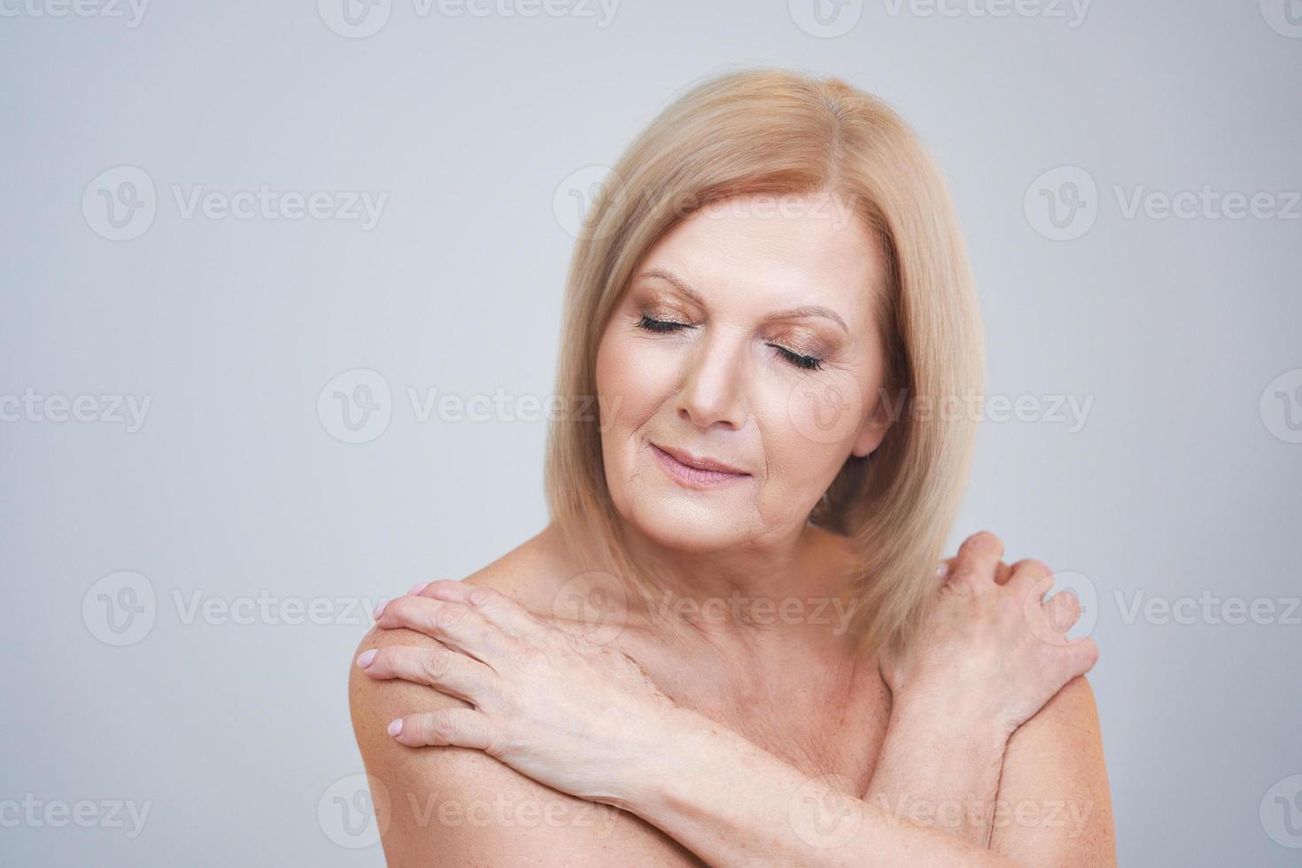 Senior woman posing over gray background photo