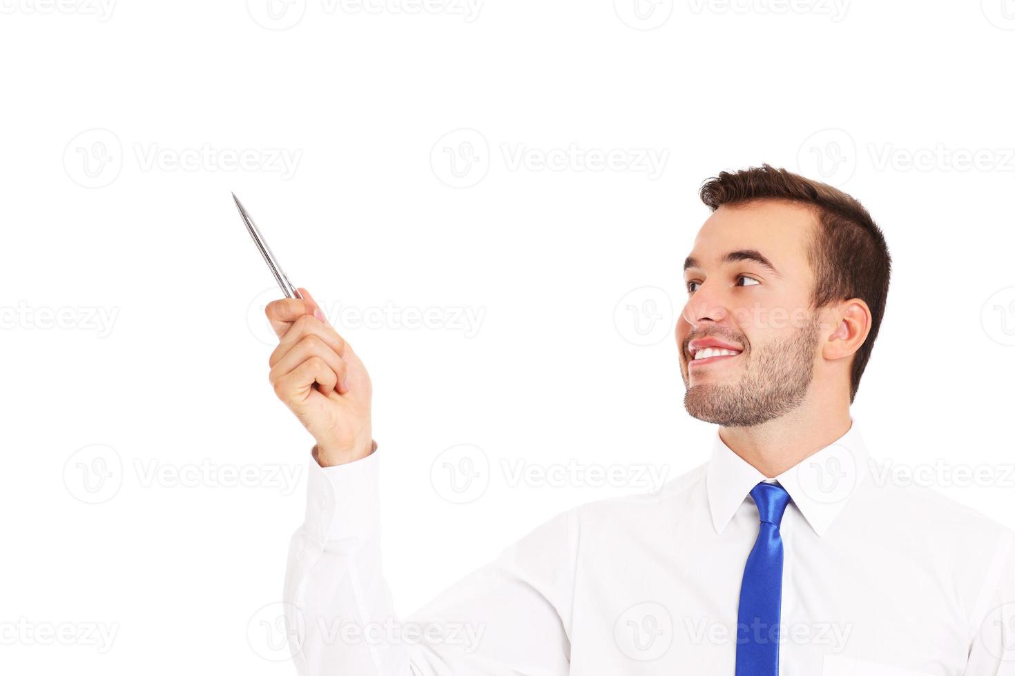 Businessman pointing at something with a pen photo