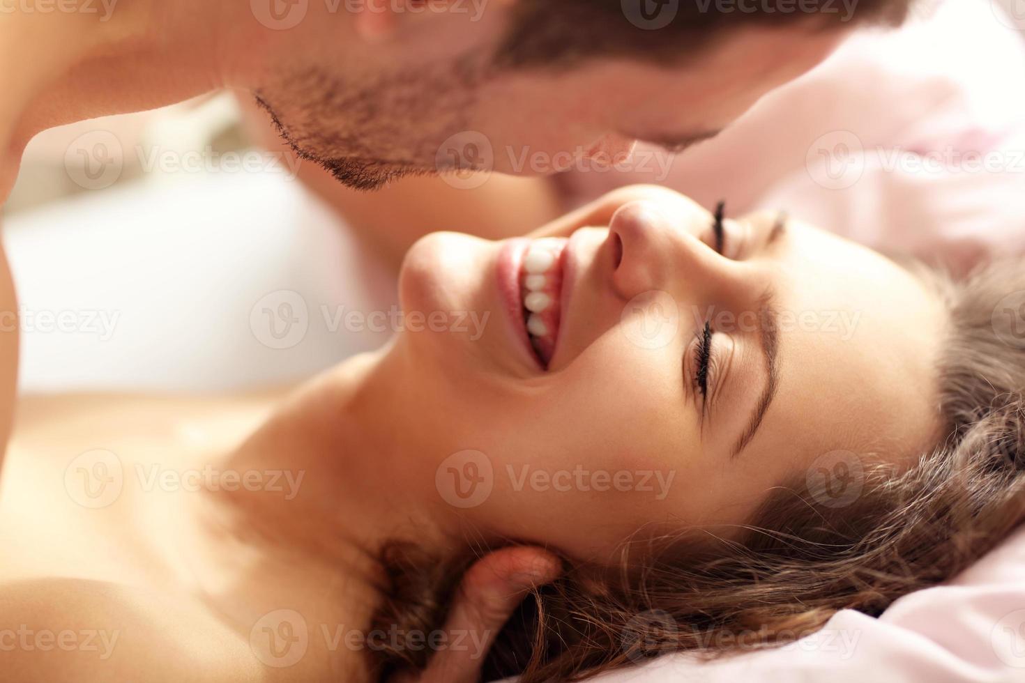 Adult couple kissing in bed photo