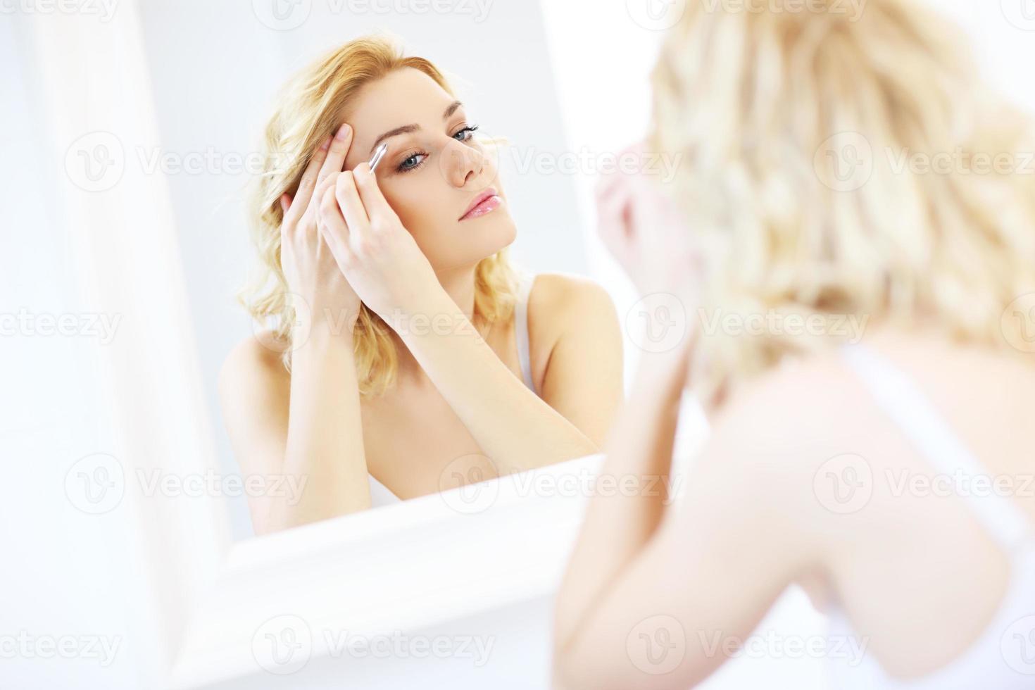 Woman shaping eyebrows photo