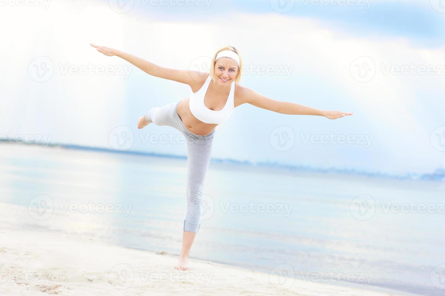 mujer joven haciendo ejercicio en la playa foto