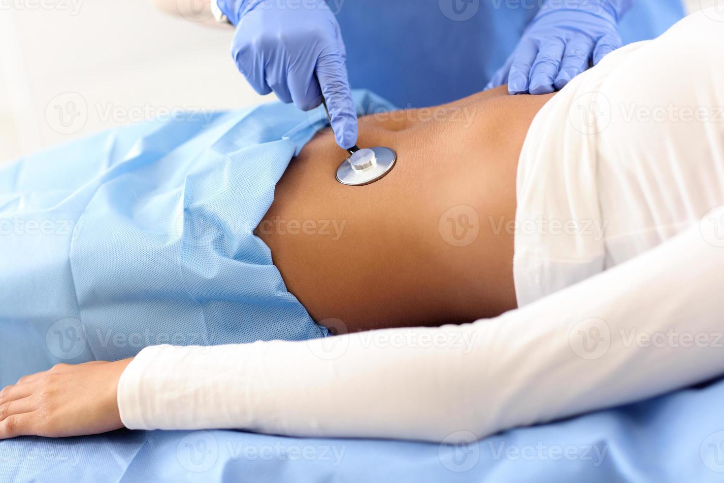 Adult woman being examined with stethoscope by female doctor photo