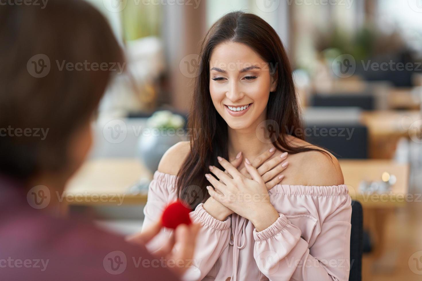 Young man proposing to his girlfriend in a cafe photo