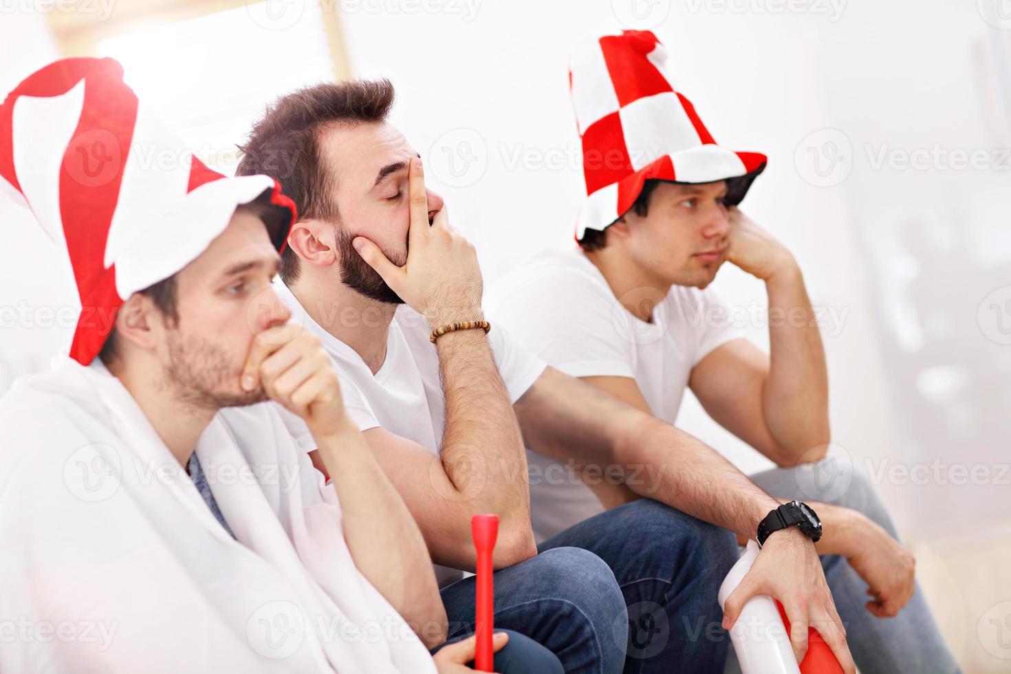 Happy male friends cheering and watching sports on tv photo