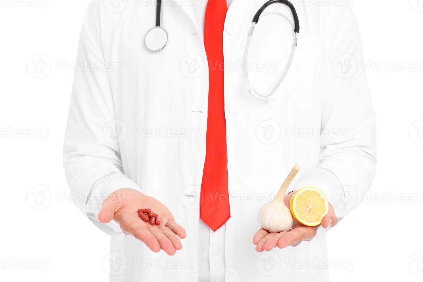 Midsection of doctor holding pills and lemon with garlic photo