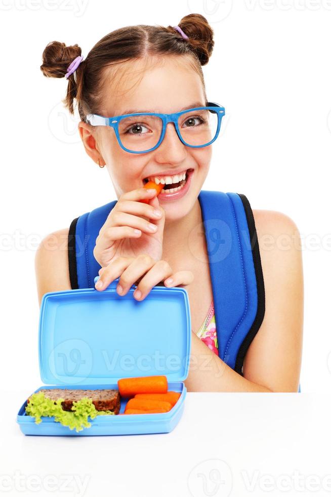 Schoolgirl eating healthy lunch photo