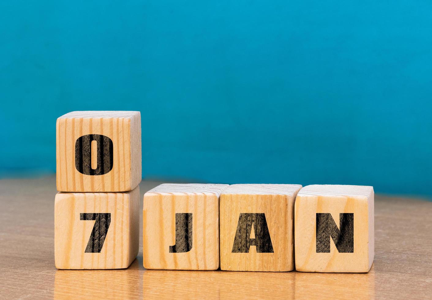 Cube shape calendar for January 07 on wooden surface with empty space for text,cube calendar for January on wood background photo