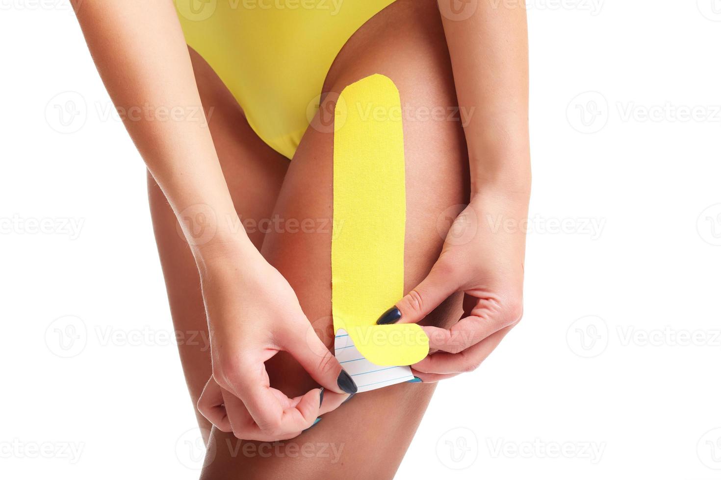 Picture showing special physio tape put on injured thigh over white background photo