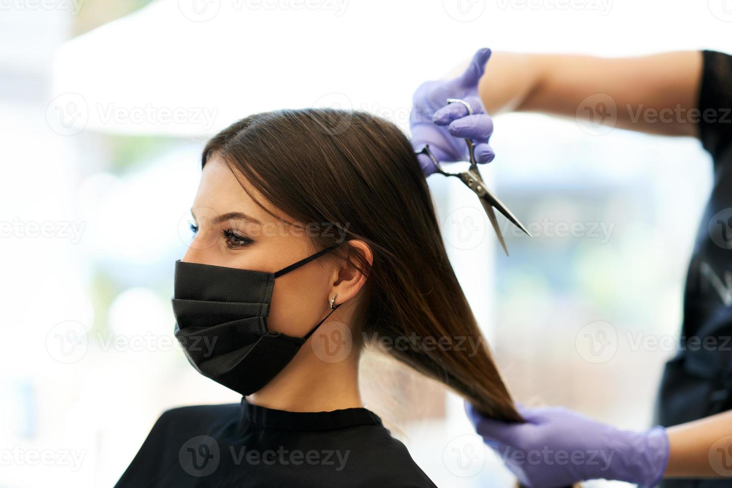Adult woman at hairdresser wearing protective mask due to coronavirus pandemic photo