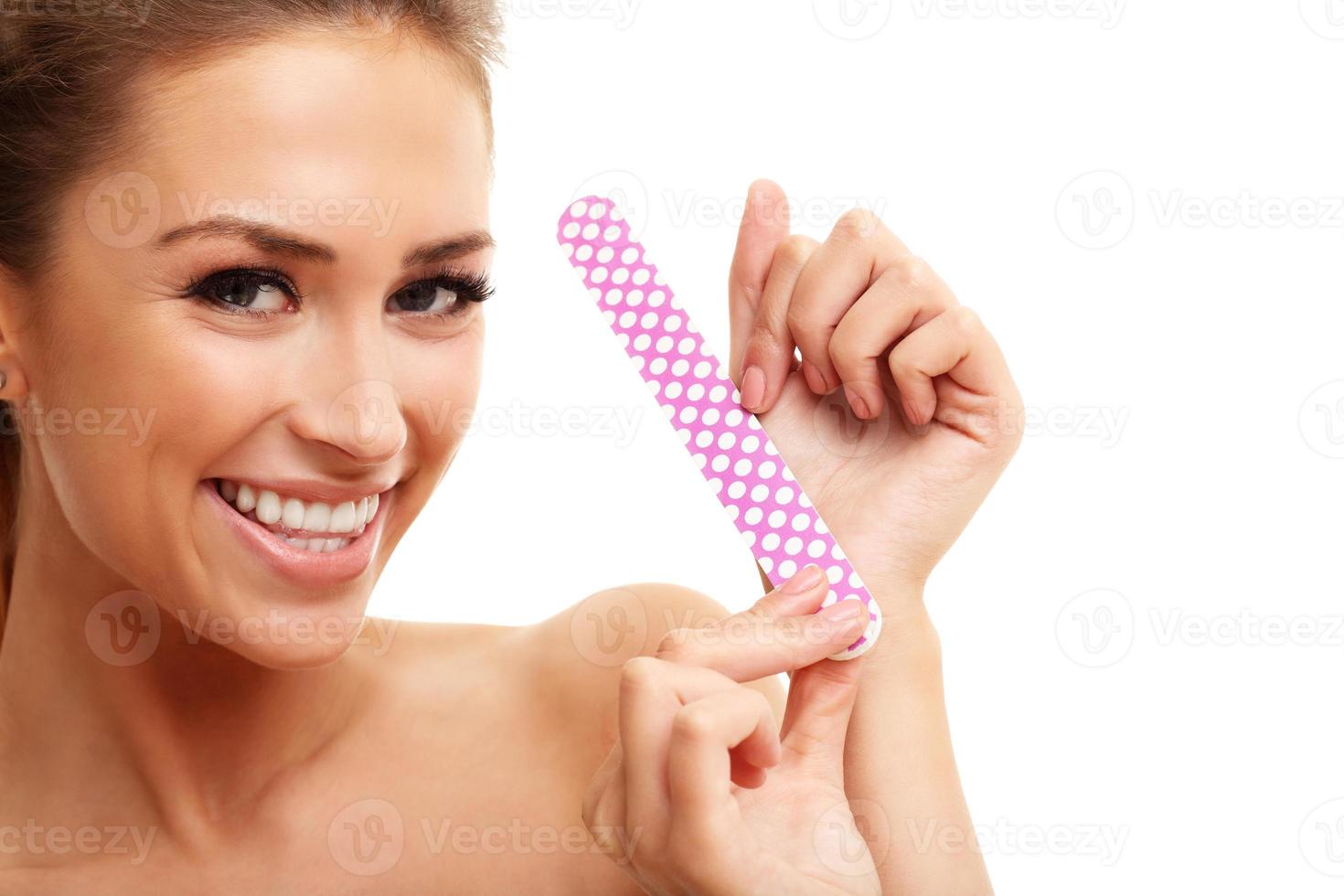 Adult woman polishing fingernails with the nail file photo