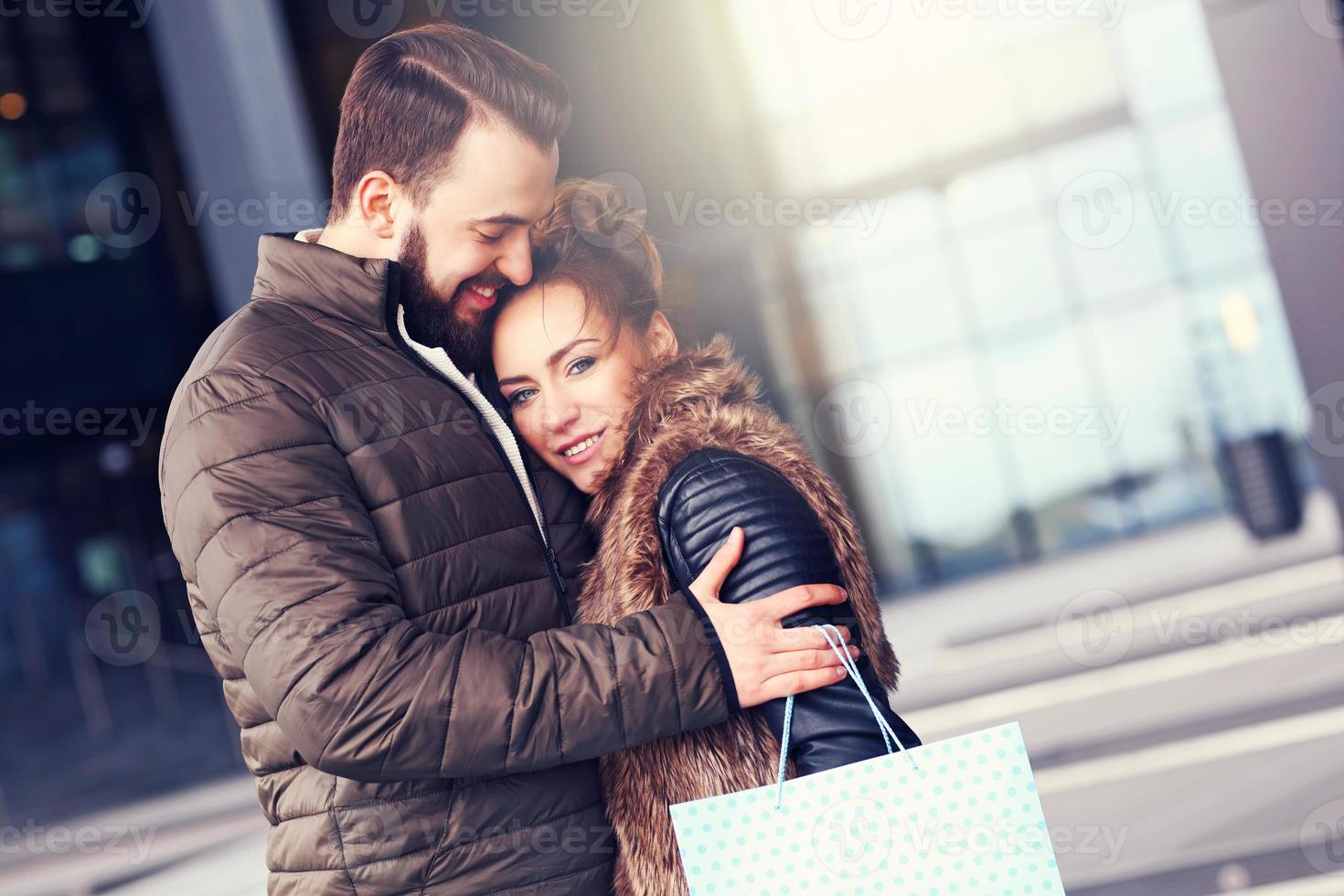 Happy couple shopping and hugging photo