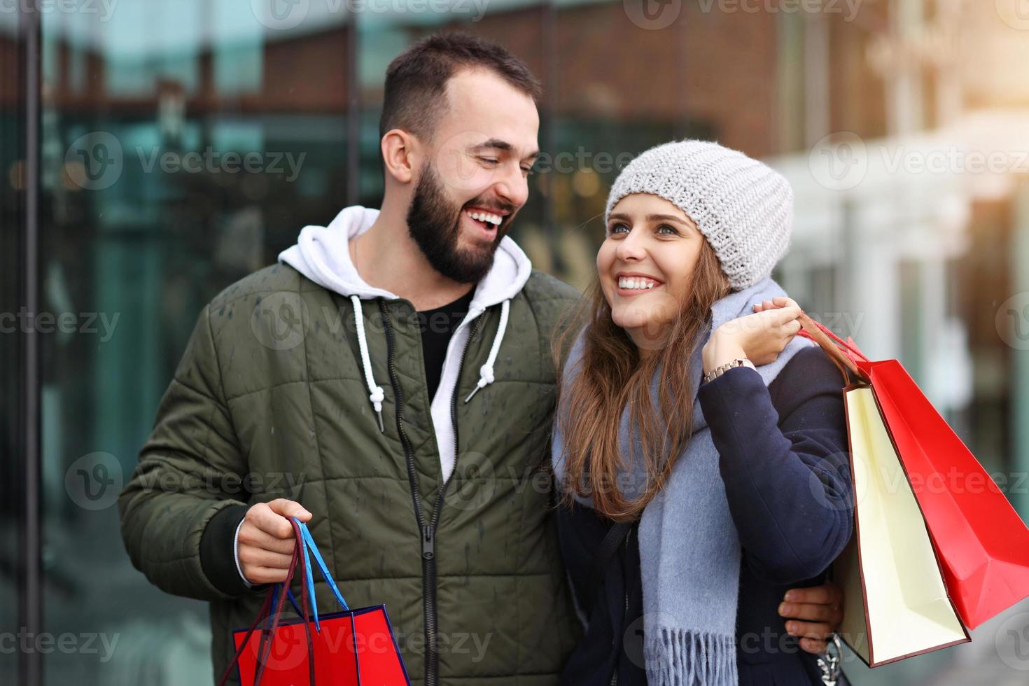 Portrait of happy couple with shopping bags after shopping in city photo