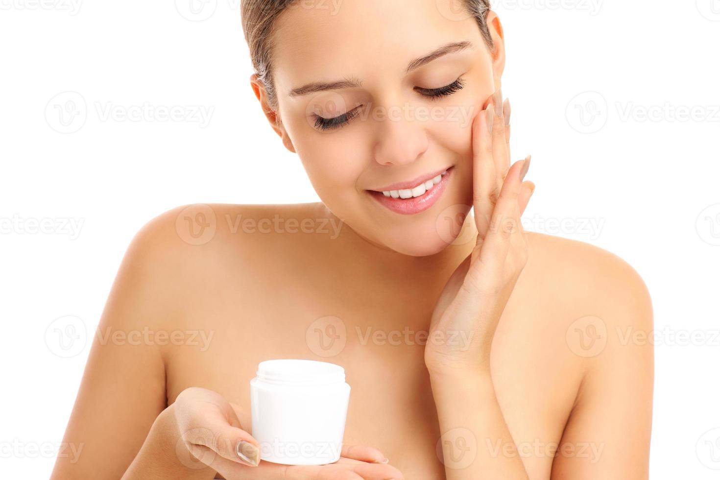 Pretty woman applying cream on face photo