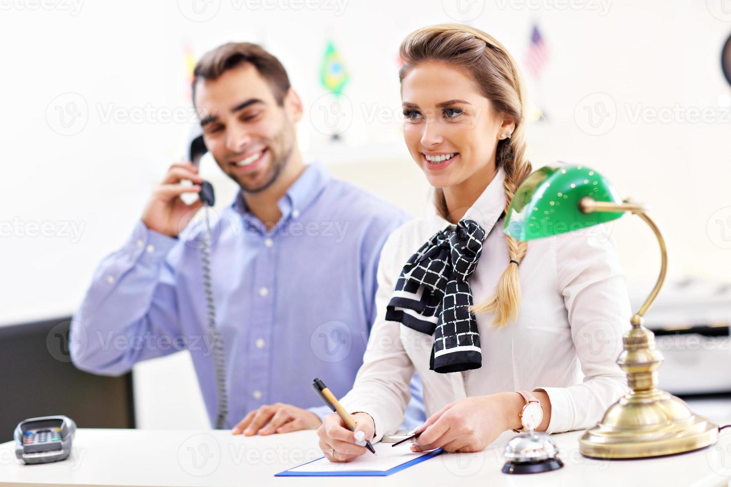 Happy team of hotel receptionists photo