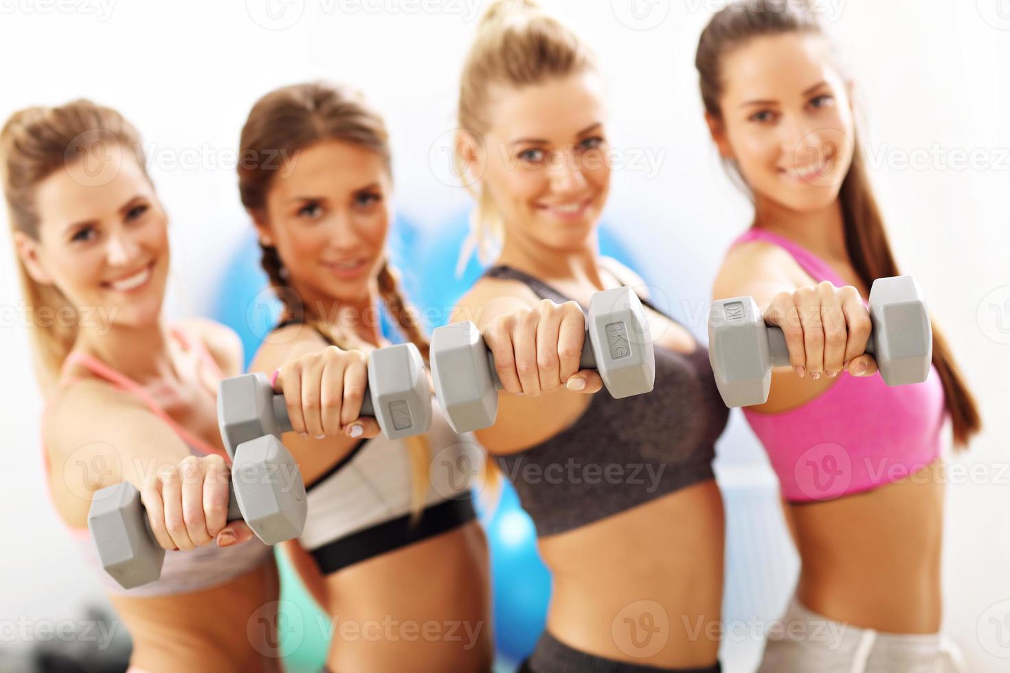 Group of smiling people lifting barbells photo