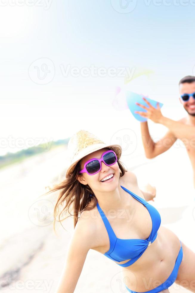 Young couple playing with a ball at the beach photo