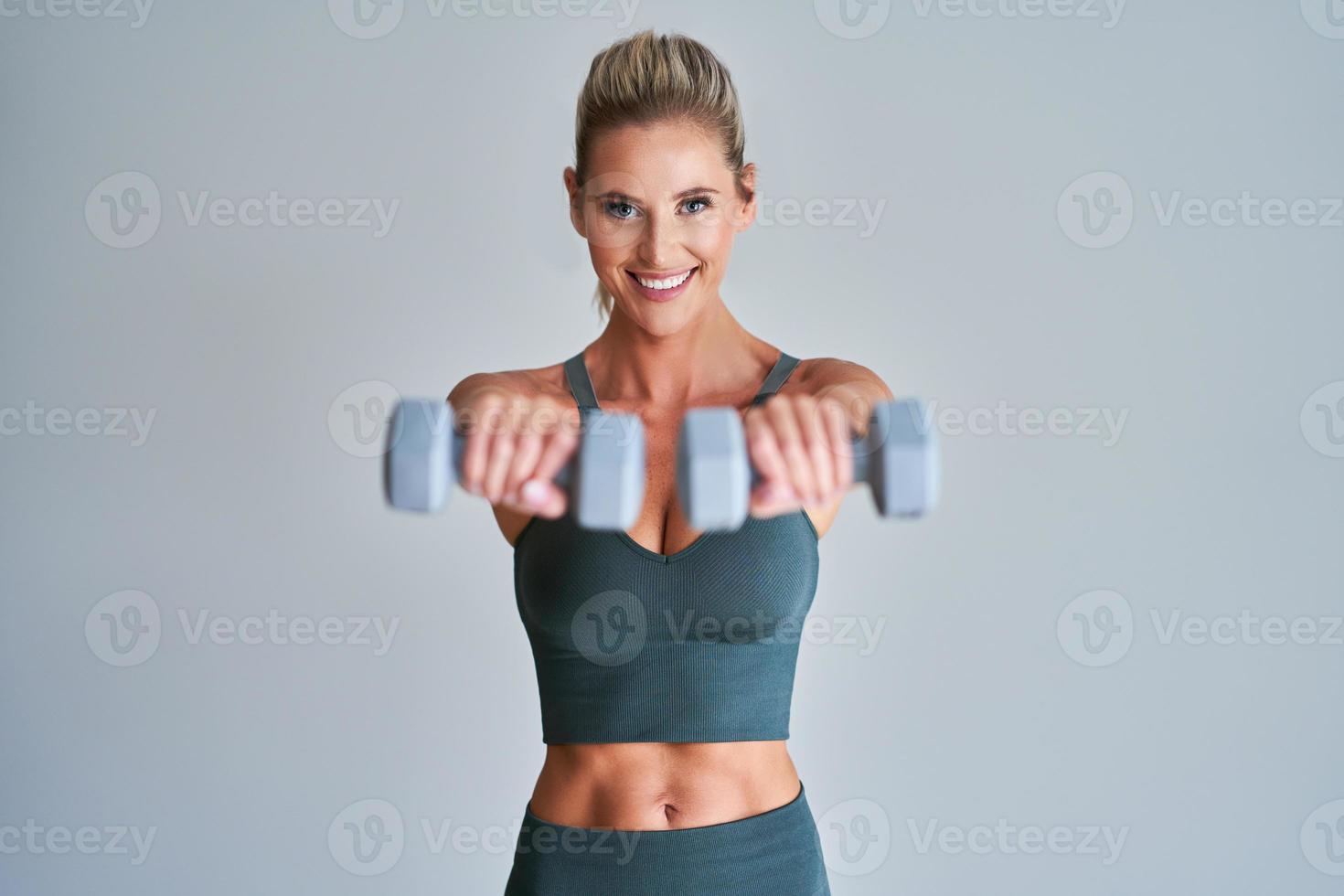 Adult woman working out with dumbells photo