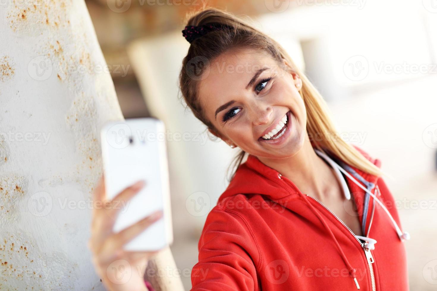 Woman jogging on the beach with smartphone photo