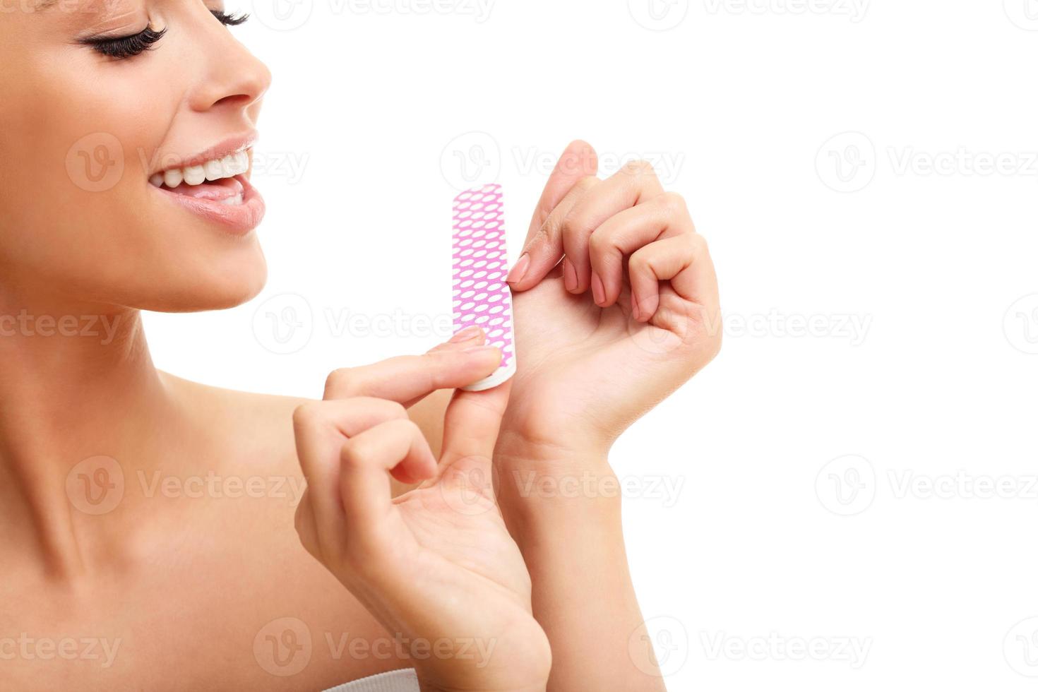 Adult woman polishing fingernails with the nail file photo