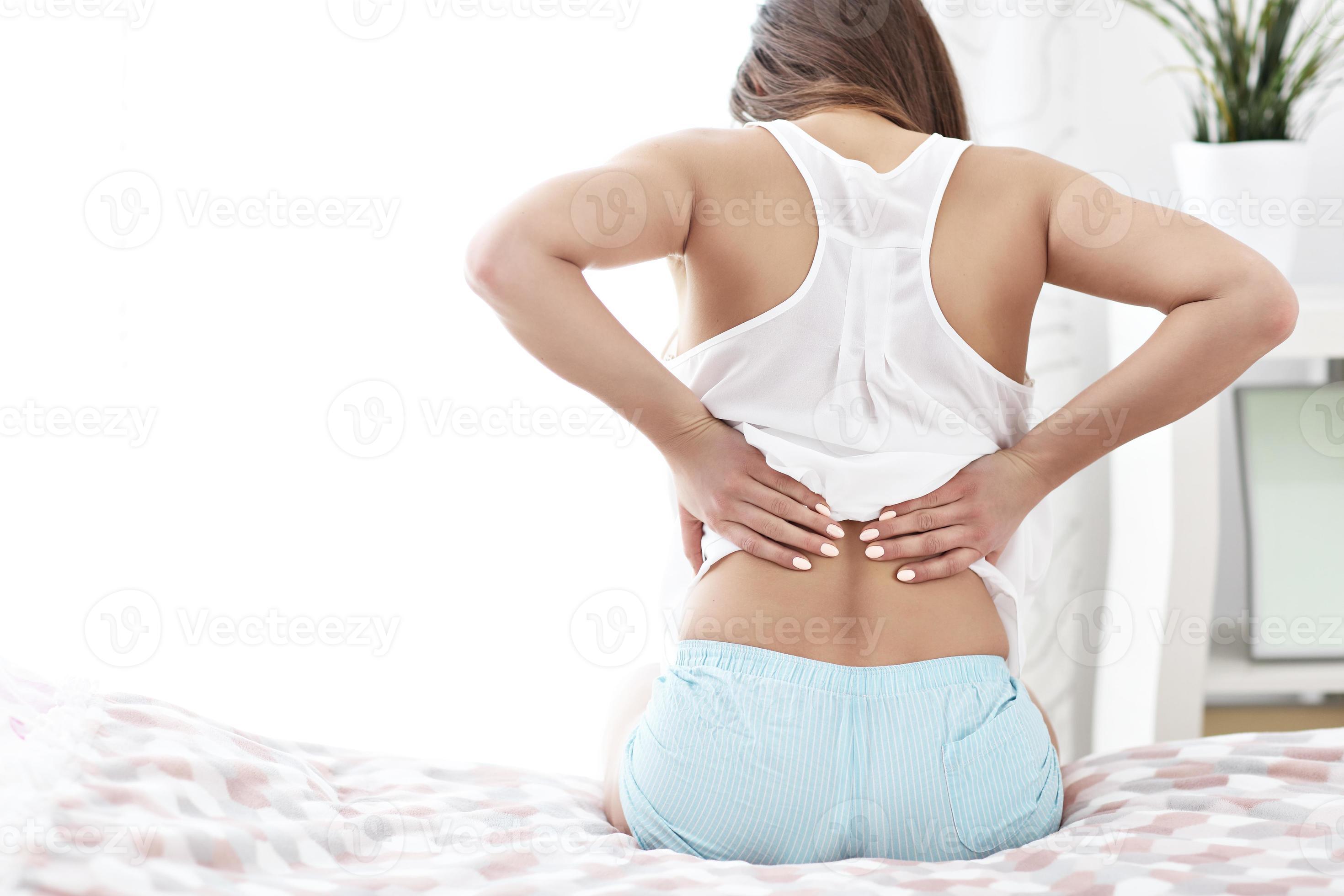 Young woman waking up in bed with backache 15813141 Stock Photo at Vecteezy