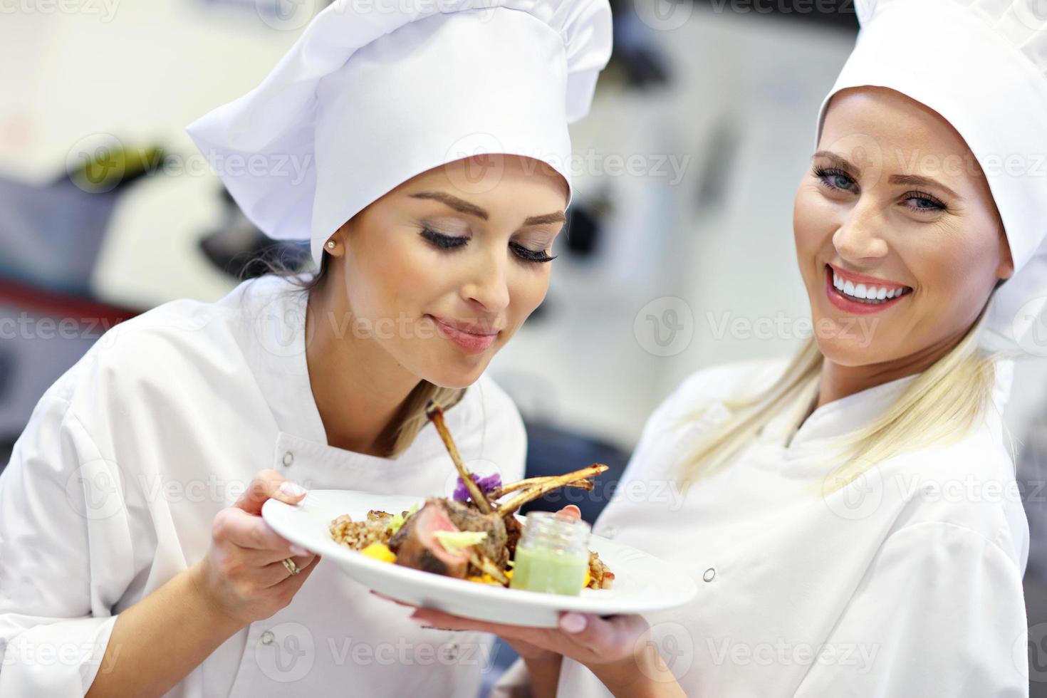 Busy chefs at work in the restaurant kitchen photo