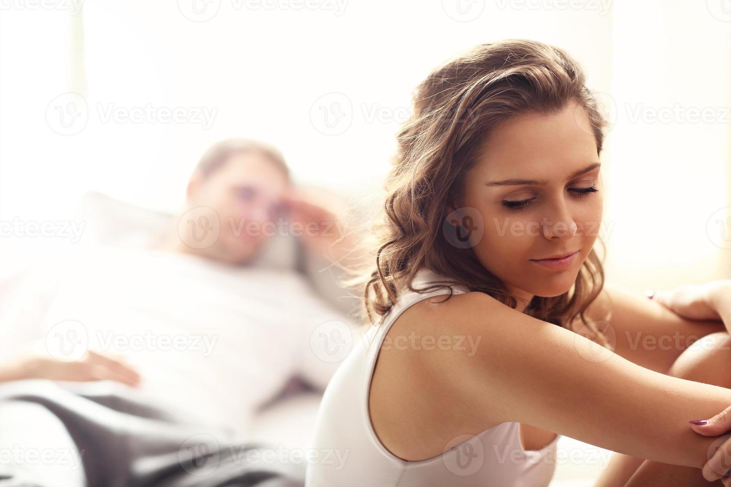 Young woman and her man having problem in bedroom photo