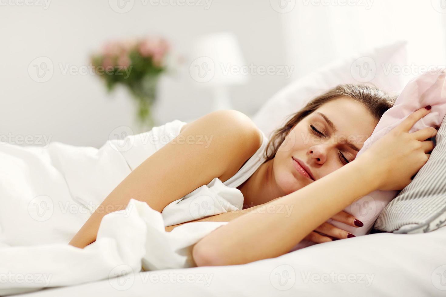 mujer joven durmiendo en la cama foto