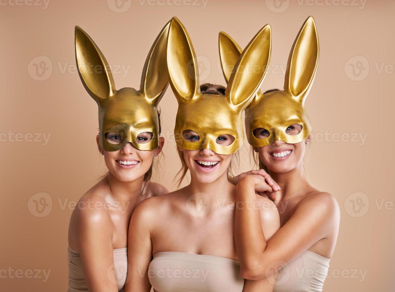 Group of beautiful women wearing bunny ears isolated over background photo