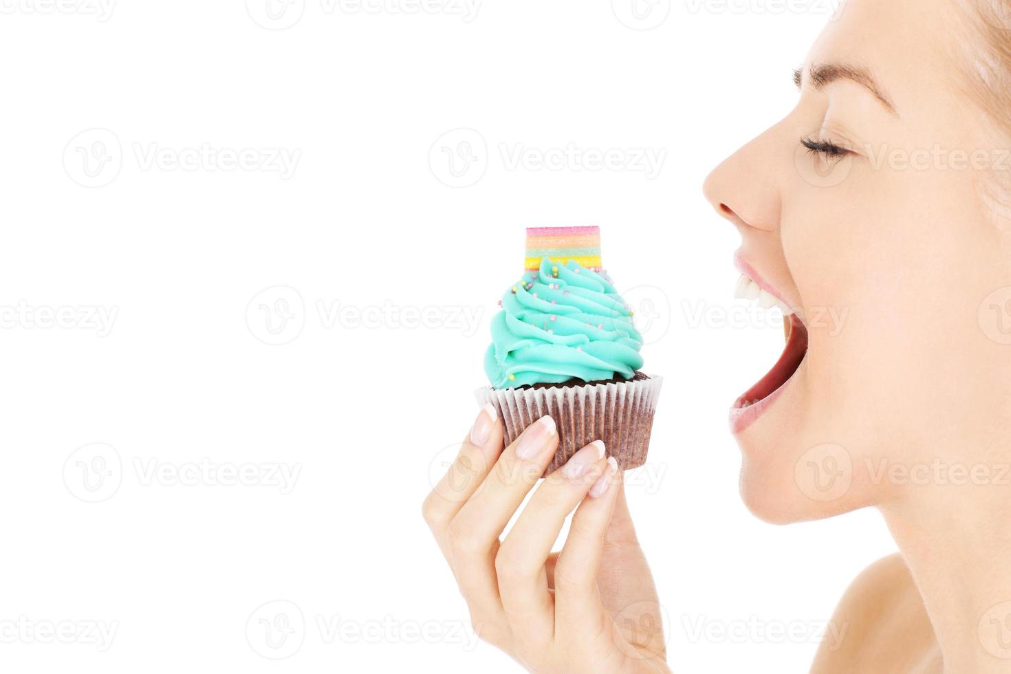 Woman biting a cupcake photo