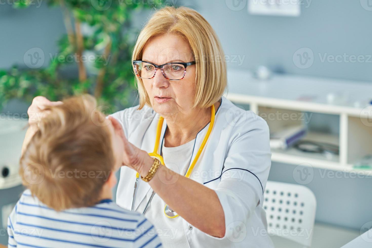 Pediatrician doctor examining little kids in clinic photo
