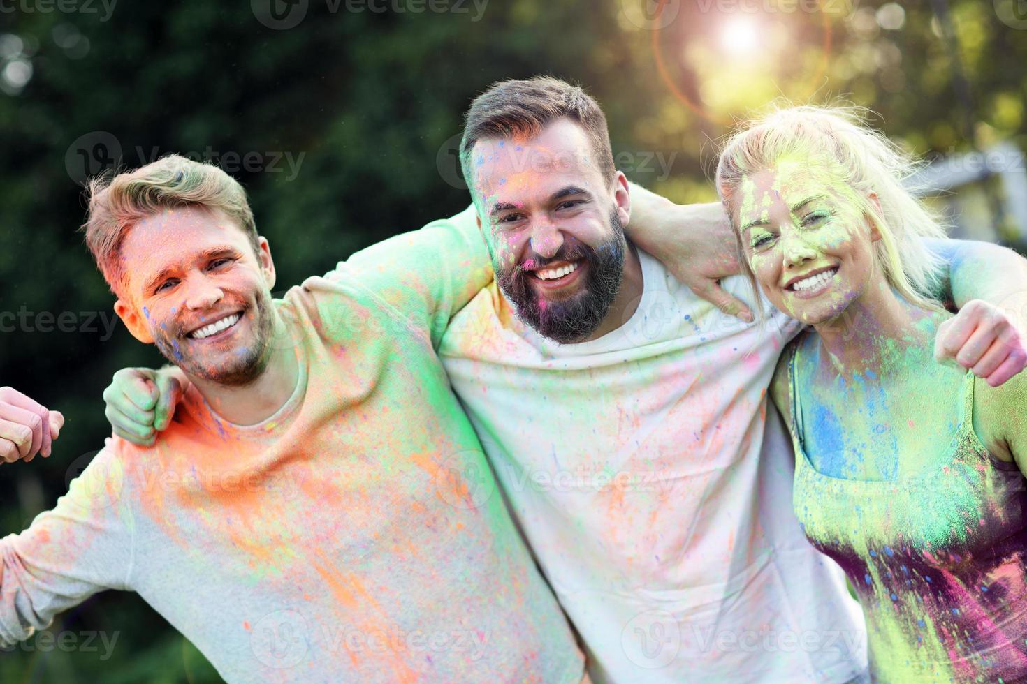 Group of friends having fun at color festival photo