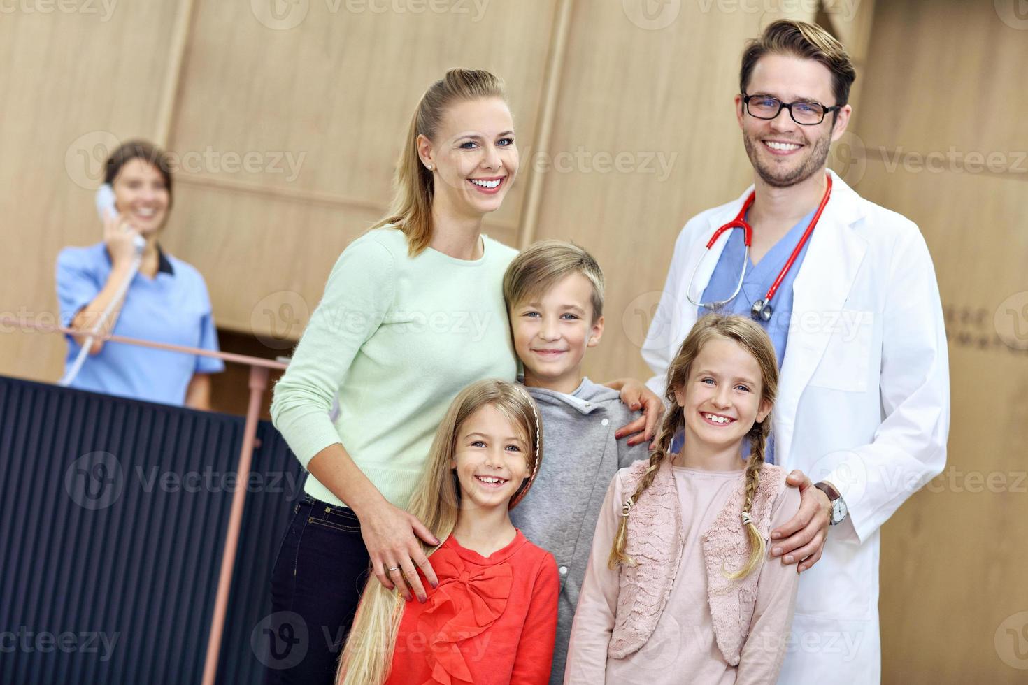 Mother and children together in hospital with doctor photo