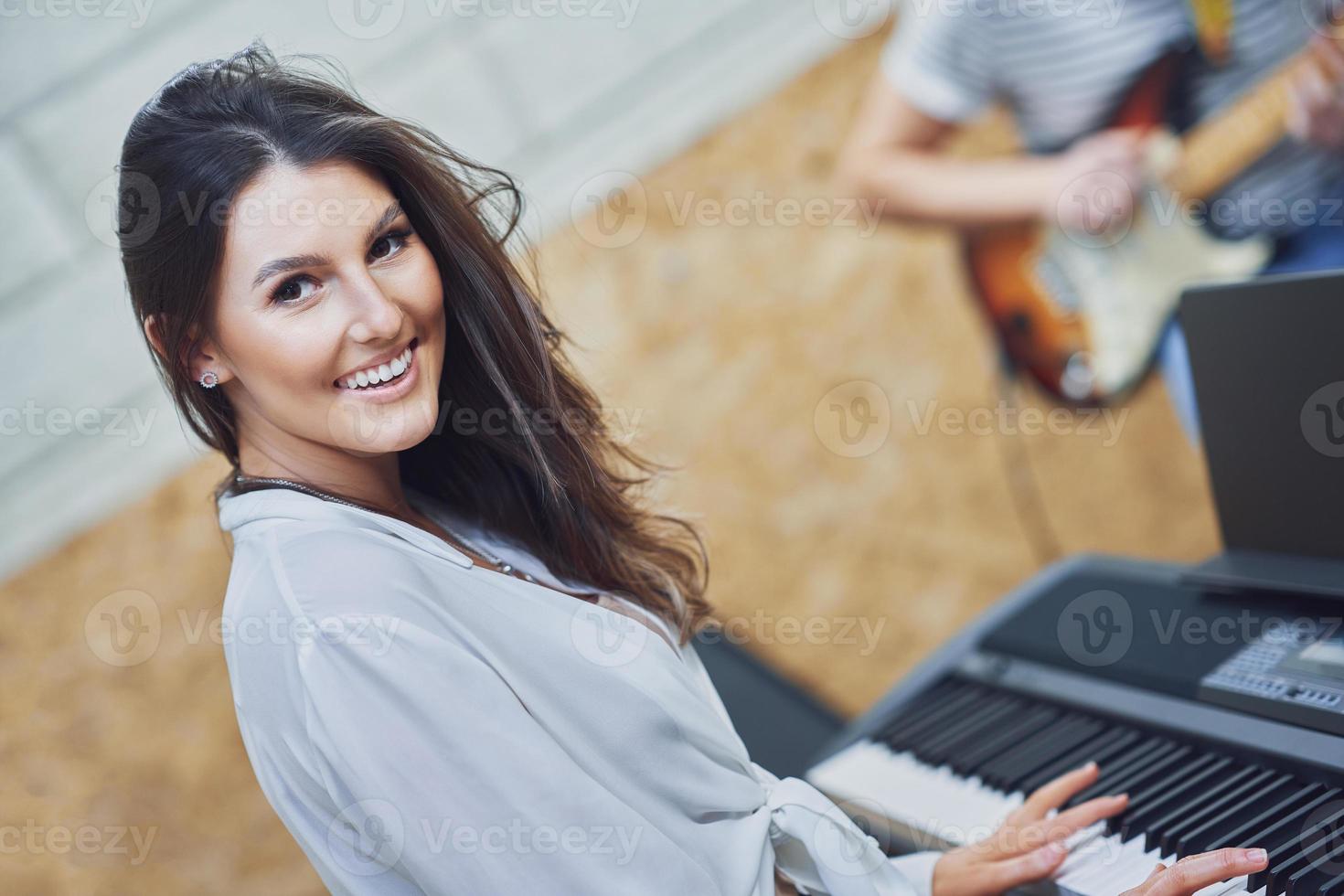 Caucasian woman playing on keyboard with band photo