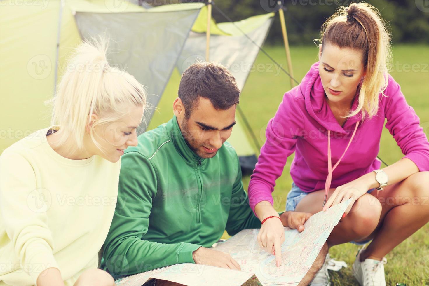 grupo de amigos acampando en el bosque y mirando el mapa foto