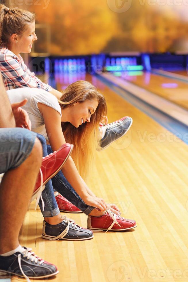 Friends putting on bowling shoes photo