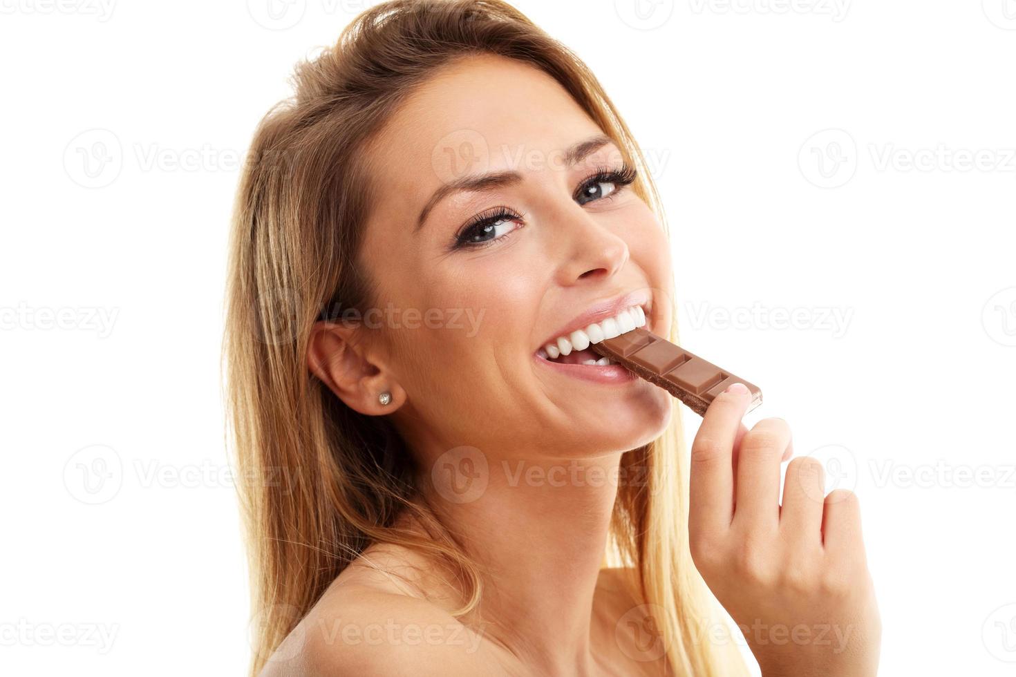 Portrait of beautiful woman holding chocolate bar photo