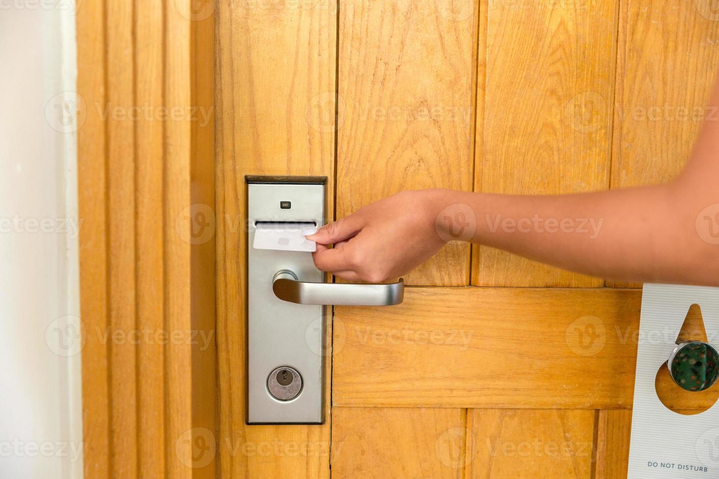 primer plano de la mano femenina sujetar la tarjeta llave y abrir la puerta de la cerradura electrónica foto