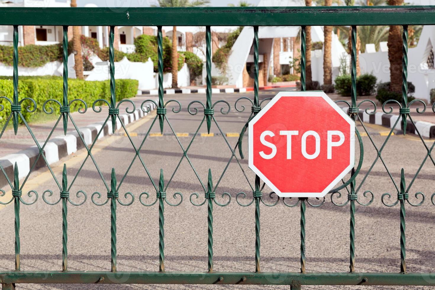 closed gate with a red stop sign at the entrance to the hotel photo