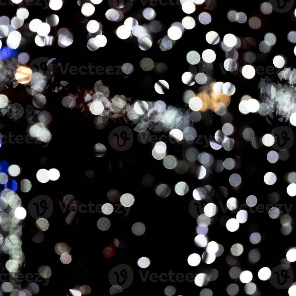 Abstract bokeh of white city lights on black background. defocused and blurred many round light photo