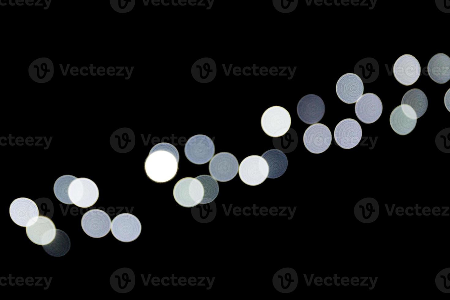 Unfocused abstract white bokeh on black background. defocused and blurred many round light photo