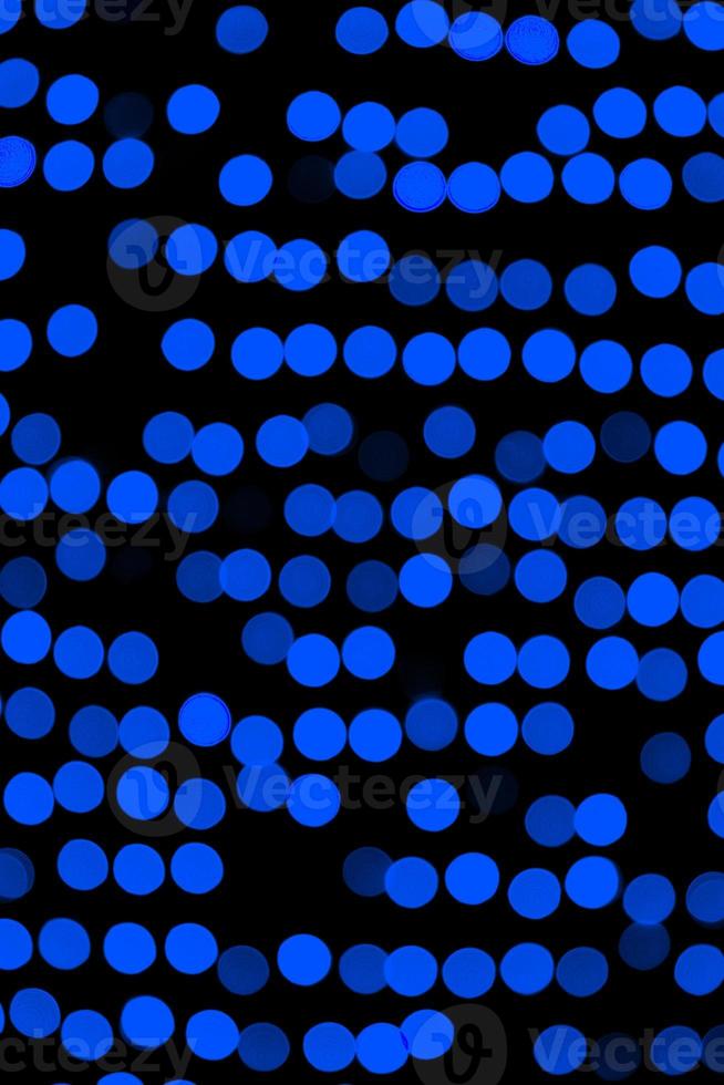 Unfocused abstract dark blue bokeh on black background. defocused and blurred many round light photo