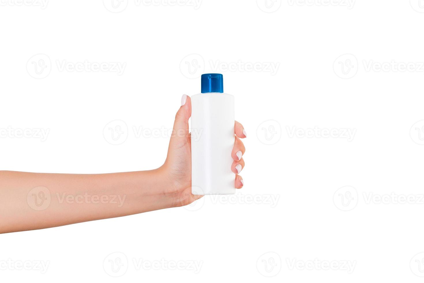 mano femenina sosteniendo una botella de crema de loción aislada. Chica dar tubo productos cosméticos sobre fondo blanco. foto
