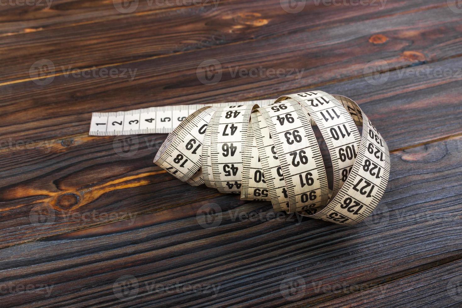 Tailoring Meter White measuring tape on wooden background photo